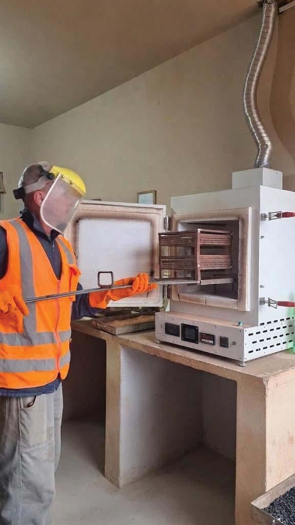 Técnico operando forno de ignição no laboratório